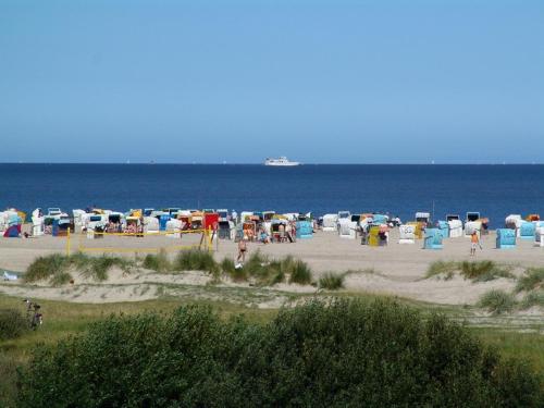 a beach with a bunch of chairs and people on the beach at Villa Petra in Norddeich