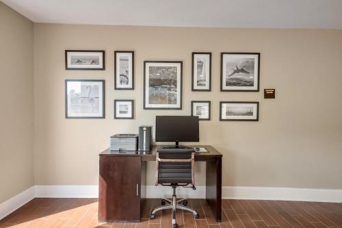 an office with a desk with a computer and framed pictures at Sleep Inn & Suites Niceville - Destin in Niceville