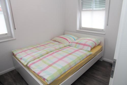 Bett in einem Zimmer mit zwei Kissen darauf in der Unterkunft Ankerplatz in Greetsiel