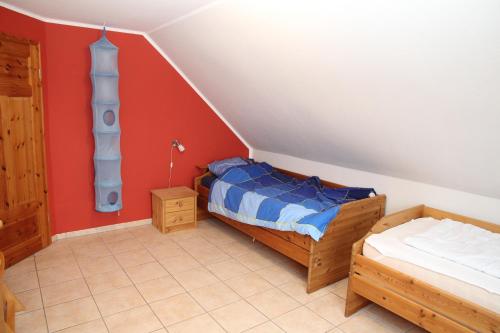 1 dormitorio con 2 camas en una habitación con paredes rojas en Friesengeist, en Norden