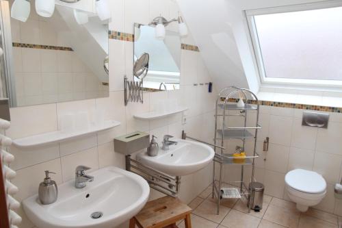 Un baño con dos lavabos y un inodoro. en Friesengeist, en Norden
