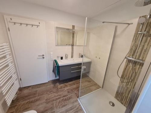 een badkamer met een wastafel en een douche bij Grachtendrööm in Greetsiel