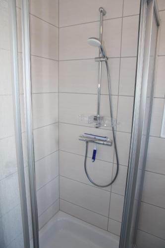 a shower with a hose in a bathroom at Bei Ruhe in Loppersum