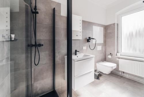 a bathroom with a shower and a toilet and a sink at Hotel Boutique am Schloss in Schleswig