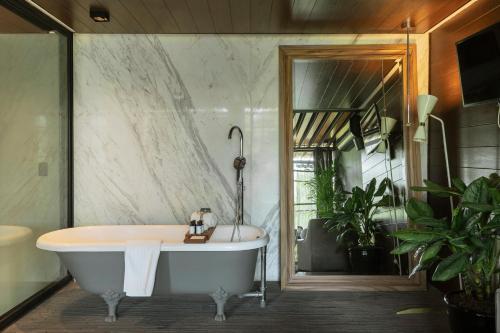 a bath tub in a bathroom with plants at Brick Hotel Mexico City - Small Luxury Hotels of the World in Mexico City