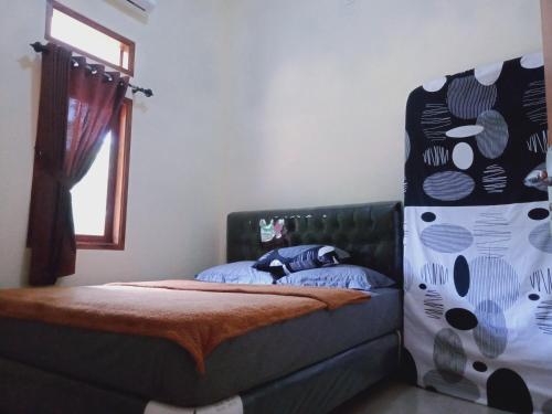 een slaapkamer met een bed en een raam bij Griya PAS Pangandaran in Pangandaran
