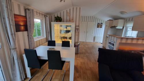 cocina y comedor con mesa blanca y sillas en Seacottage Brugge - Blankenberge - De Haan, en De Haan