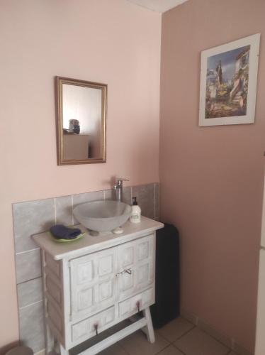 a bathroom with a sink and a mirror at Chambre spatieuse avec grand lit. in Aspet