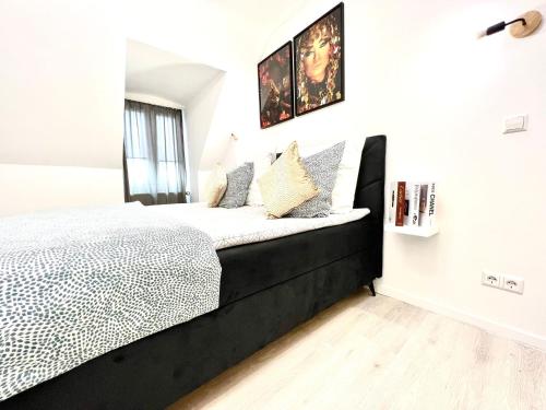 a bedroom with a black and white bed and a window at Living Solution 24 Karlsruhe in Karlsruhe