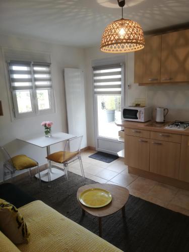 une cuisine avec une table et des chaises ainsi qu'une salle à manger dans l'établissement Chambre d'Hôte Noalhat - Zenith d'Auvergne, à La Roche-Blanche