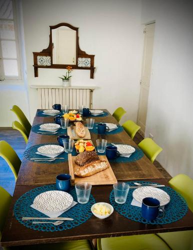 a long wooden table with plates of food on it at Le Gîte - La Ferme du Pouget in Saint-Jean-du-Gard