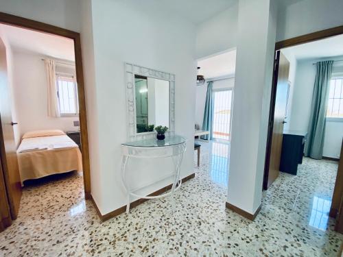 a bathroom with a glass sink and a mirror at Apartamentos Turísticos Santo Rostro in Chipiona