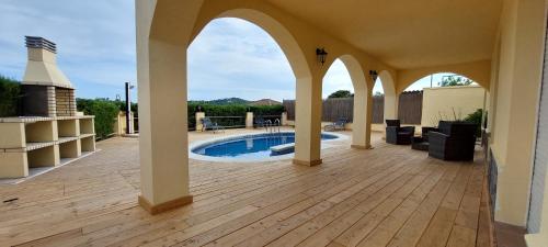 an outdoor patio with a pool and an archway at LA VILLA DEL PARAISO in Vidreres