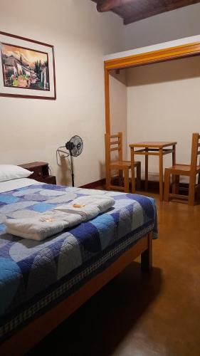 ナスカにあるブラバント ホステルのベッドルーム1室(ベッド1台、テーブル、椅子付)