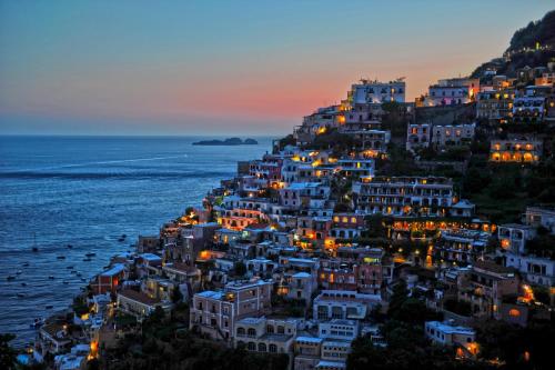 a town on a hill with the ocean at night at Hotel Royal Positano in Positano