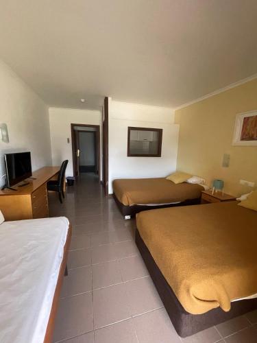 a hotel room with two beds and a flat screen tv at Juiceven Studios in Alcabideche