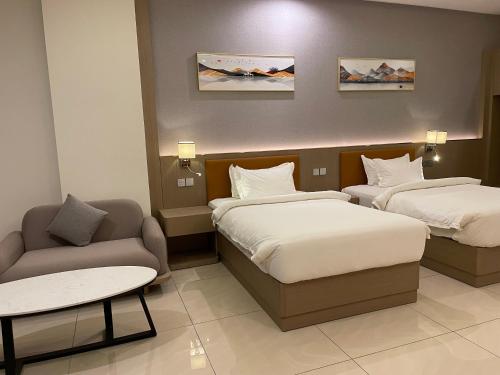 a hotel room with two beds and a couch at Season Inn Hotel_Al Hail in Seeb