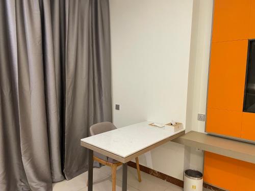 a table and chair in a room with a curtain at Season Inn Hotel_Al Hail in Seeb