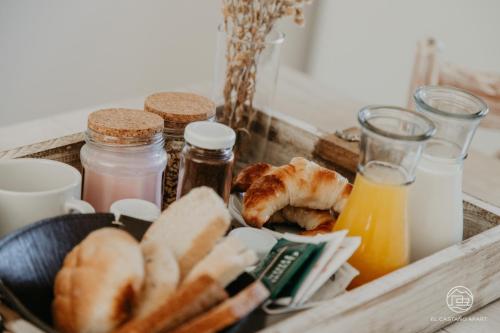 a tray of food with bread and bottles of orange juice at El Castaño Apart in Potrerillos