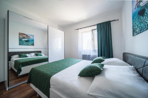1 dormitorio con 2 camas y espejo en Apartment Matteo en Bale