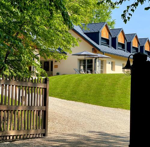 a house with a wooden fence in front of it at Loft Naturalpina Dolomiti Farm in Belluno