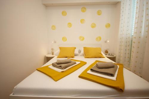 a bedroom with a white bed with yellow towels on it at Apartment Passage Dubrovnik in Dubrovnik
