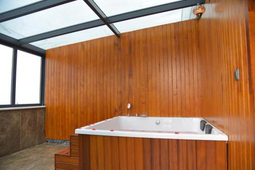 a large bath tub in a room with wooden walls at Aselia Hotel Trabzon in Trabzon