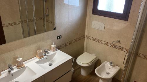 La salle de bains est pourvue d'un lavabo, de toilettes et d'un miroir. dans l'établissement Villa Alma, à Collepasso