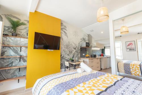 - une chambre avec un lit et un mur jaune dans l'établissement Cosy Apparts Saintes, à Saintes
