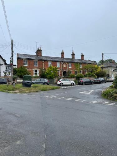 an empty street with cars parked in front of a building at Cobwebs in Kedington