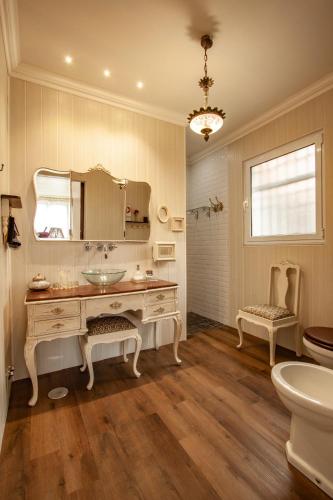 a bathroom with a sink and a mirror and a toilet at Casa da Porta Amarela in Sete Cidades