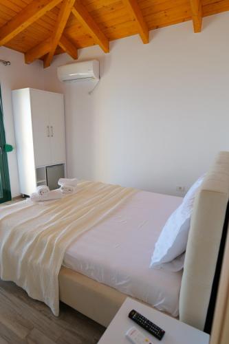 a bedroom with a bed and a desk with a remote control at Alex & Sofi Apartments in Himare