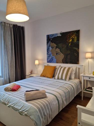 1 dormitorio con 1 cama grande y una gran pintura en la pared en Oldtown Parliament self check in en Bucarest
