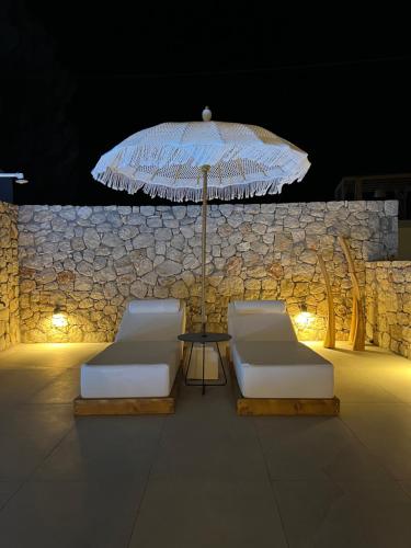 a patio with two chairs and an umbrella at Milos Villas Complex in Pefki Rhodes