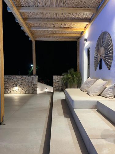 a patio with a bed and a clock on the wall at Milos Villas Complex in Pefki Rhodes