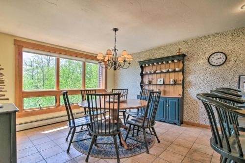a dining room with a table and chairs and a clock at Timber Creek Townhome with 2 Decks and Mtn Views! in West Dover