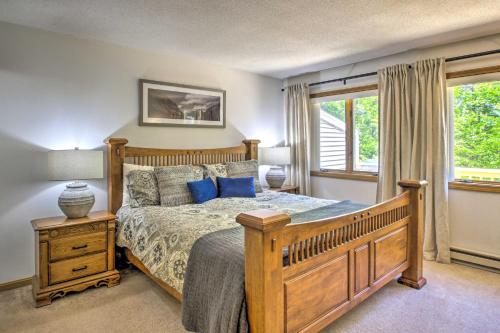 a bedroom with a wooden bed with blue pillows at North Conway Condo in the White Mountains! in North Conway