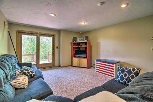 a living room with a blue couch and a tv at Timber Creek Townhome with 2 Decks and Mtn Views! in West Dover