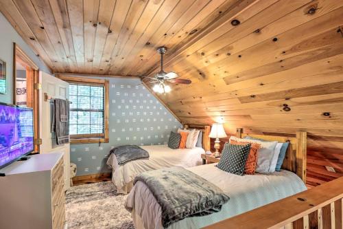 two beds in a room with wooden ceilings at Bumblebee Cottage Murphy Retreat with Hot Tub in Salem