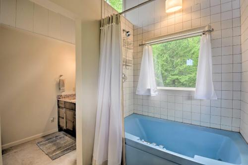 baño con bañera azul y ventana en Cabin with Balcony and Mtn Views Near Sky Valley!, en Dillard