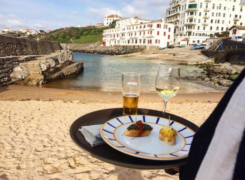 a table with a plate of food and a glass of wine at T3 GUÉTHARY - PARLEMENTIA in Guéthary