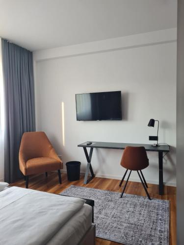 a hotel room with a desk and a television at Internationales Studierendenhotel in Stuttgart