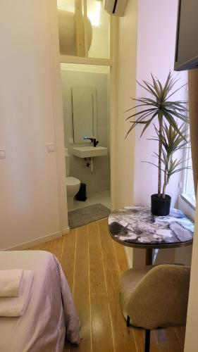 a room with a table and a potted plant in it at Tiny Studio Rosa - Bairro Alto in Lisbon