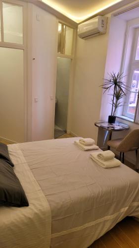 a bedroom with a bed with two towels on it at Tiny Studio Rosa - Bairro Alto in Lisbon