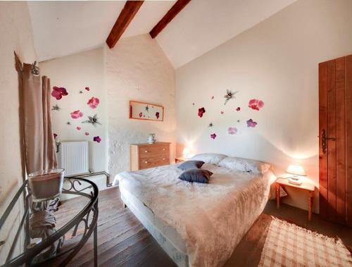 - une chambre avec un lit orné de fleurs sur le mur dans l'établissement Holiday home La Brijopa, à Bazoges-en-Pareds