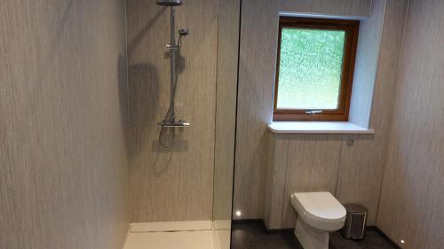 a bathroom with a toilet and a window at Bunroy Park in Fort William