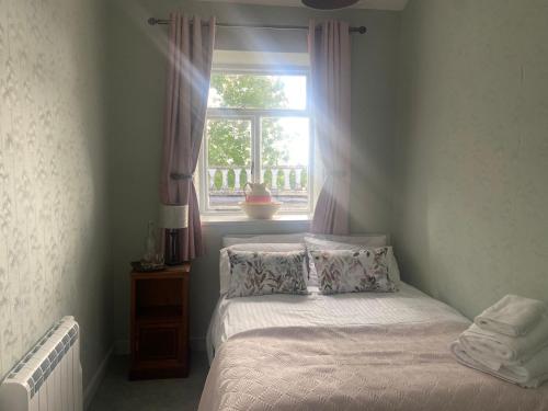 a small bedroom with a bed and a window at 29 The Square in Listowel
