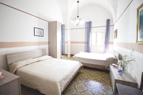 sypialnia z 2 łóżkami, stołem i oknem w obiekcie Casa Camoro a 150 mt dal mare w mieście San Foca