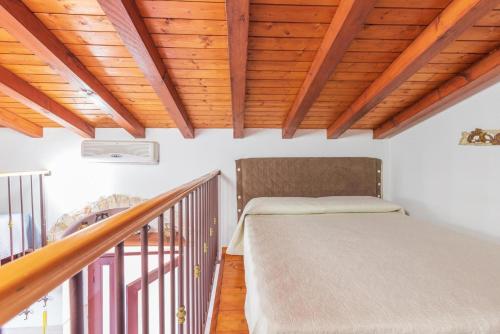 a bed in a room with a wooden ceiling at Casetta con piscina fra Catania e Siracusa in Lentini