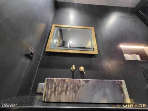 a bathroom with a sink and a mirror at La Mirage Villa in Rrushkull